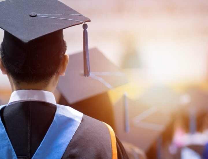 Rear view of university graduates wearing graduation gown and cap in the commencement day